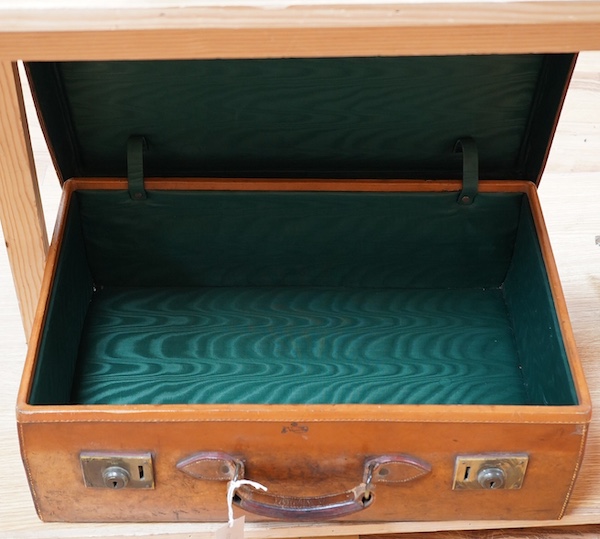 An early 20th century J. C. Vickery tan leather suitcase with green silk lining, initials stamped S.C.C. 60.5cm long, 39cm high. Condition - worn